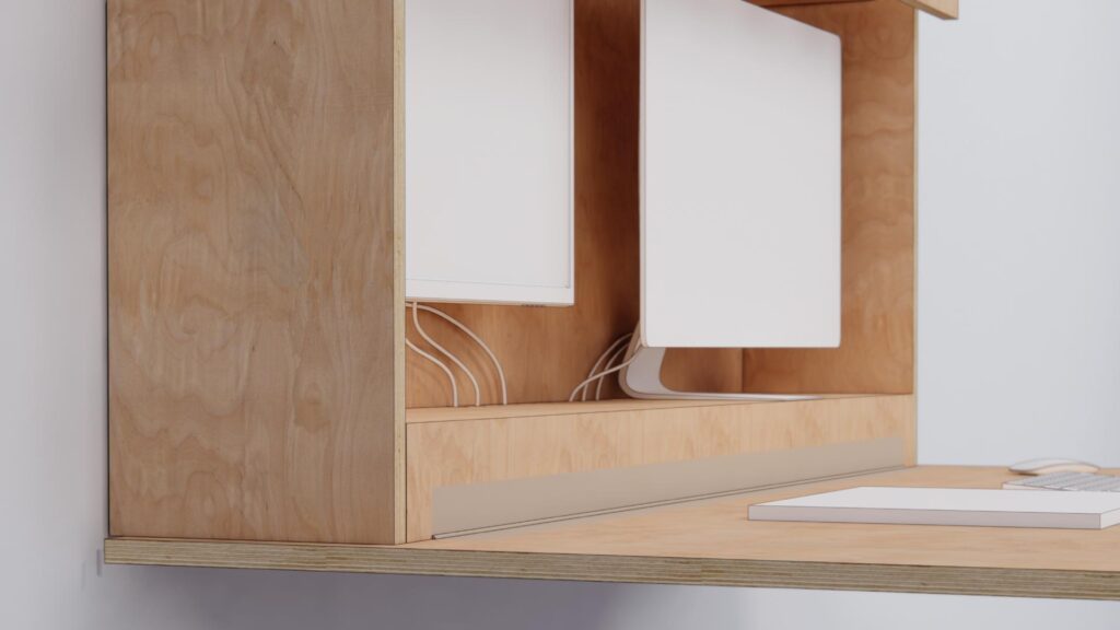 Væghængt skrivebord i birkekrydsfiner med foldbar bordplade og integreret kabelføring, monteret med fransk ophæng og udstyret med dobbelt skærme – designet af Simple Space som funktionel løsning til hjemmearbejde.